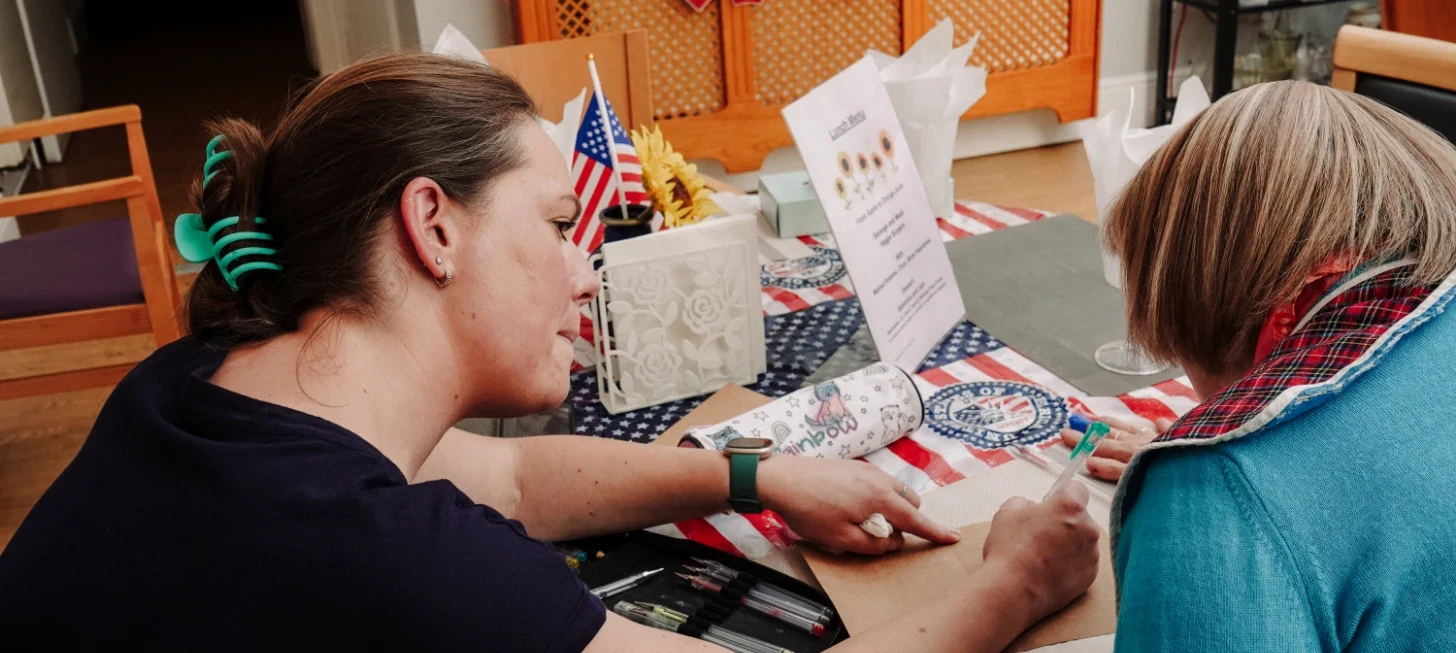 nurse assisting a woman with writing